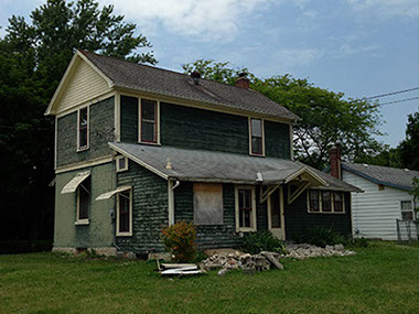green siding, grass, covered door