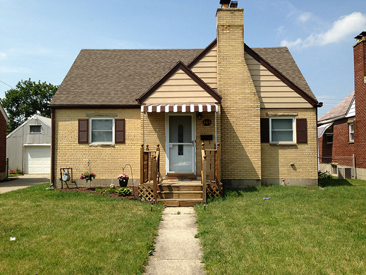 yellow brick, small covered front entry, chimney