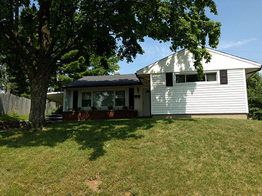 sloped front yard, large tree, white siding