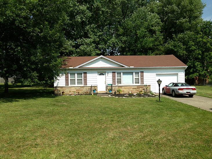 large grass frontyard, stone and white siding